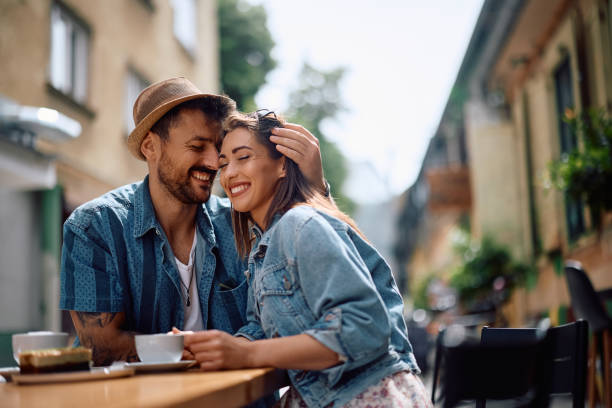 istock Young couple in love enjoying while sitting at sidewalk cafe. 2157291907
