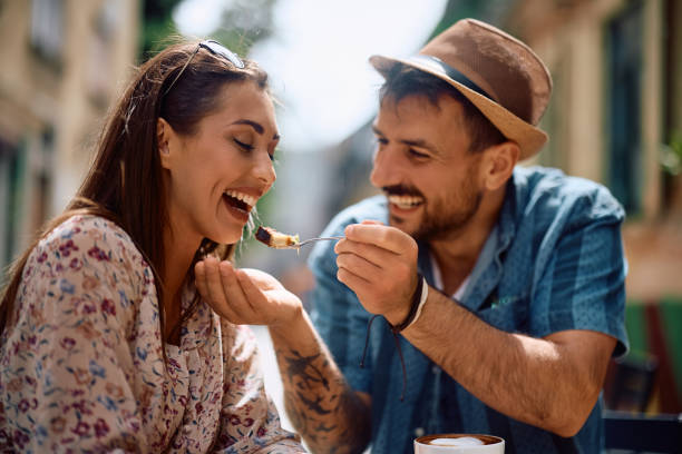 istock Happy man feeding his girlfriend with a cake in cafe. 2157291944