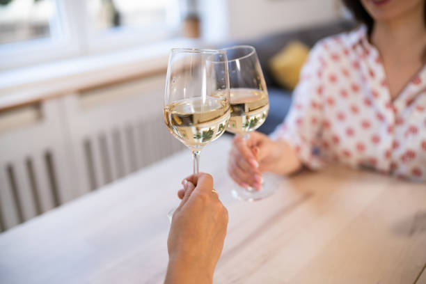 istock Unrecognizable Caucasian female friends drinking white wine at home 2157295237