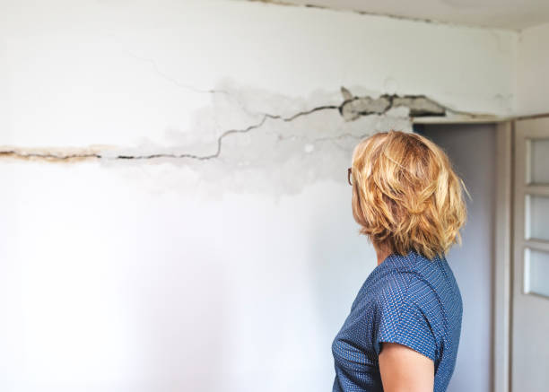 Woman looking at a wall damaged after the earthquake