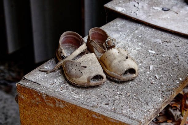 istock Dusty sandals with holes and a broken strap on a ledge. 2157302254