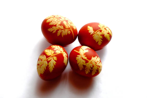 istock The image shows four red eggs with intricate yellow leaf patterns displayed against a white background. 2157302825