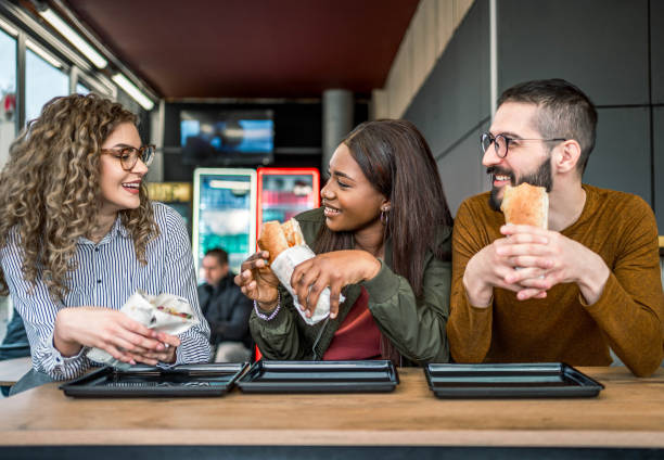 istock Friends having lunch together in a fast-food restaurant 2157303597