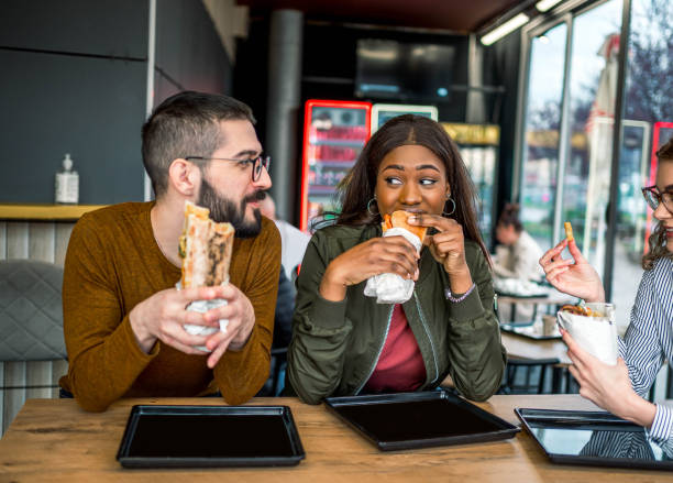 istock Friends enjoying lunch at a fast-restaurant 2157304022