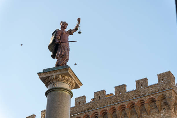 The Statue of Justice overlooking the Piazza della Signoria in Florence, Italy, against a clear blue sky, embodying fair governance