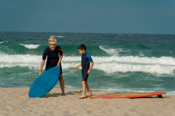 istock Mother teaching son to balance on surfboard 2157307093