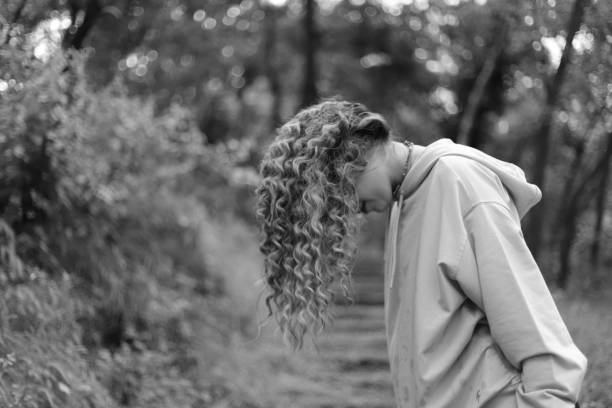 Sad girl standing alone outdoors.
