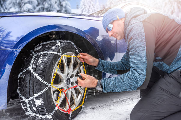 istock Putting snow chains on the front wheel of the drive axle. 2157307560