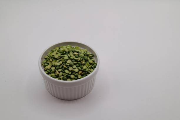 istock White bowl filled with green split peas against a plain white background 2157308346