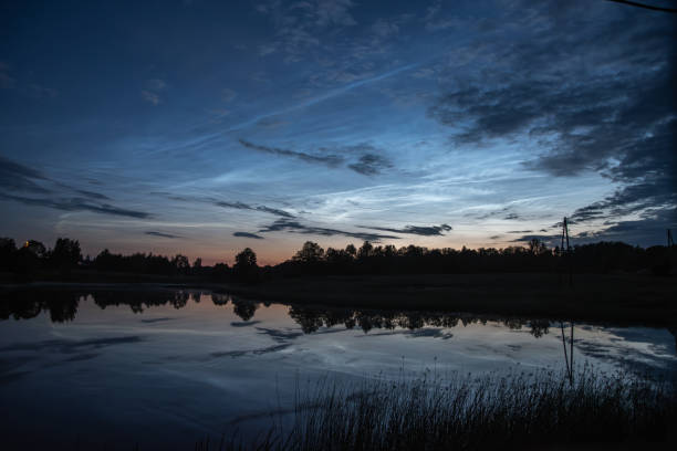 istock silver clouds reflected in the lake on a summer night with the moon above the trees 2157312513