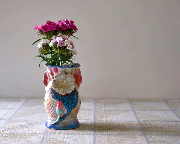 Delicate small modest pretty brightly coloured meadow flowers stand out strongly against dark rich interiors and bright window light.