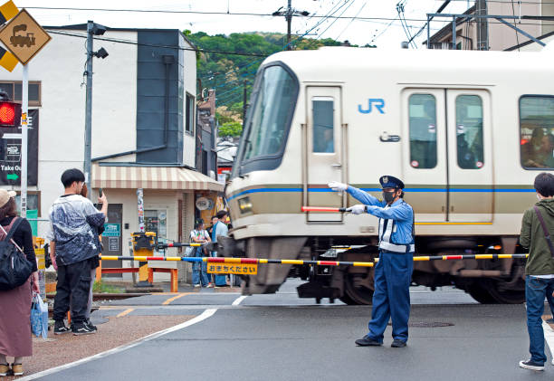 Railway crossing with train, Nara, Nara Prefecture, Japan. Nara once capital of Japan is now the capital of Nara Prefecture, with significant temples and artwork dating to the 8th century. Deer roam in Nara Park, site of Tōdai-ji temple. Daibutsu. Honshu, Japan’s main island with most of the country’s major cities and cultural sites. From the busy global hub of Tokyo for finance, industry, fashion and cuisine to Mount Fuji, the iconic, snow-capped volcano and the city of Kyoto, famed for Zen temples, gardens and traditional geisha entertainment