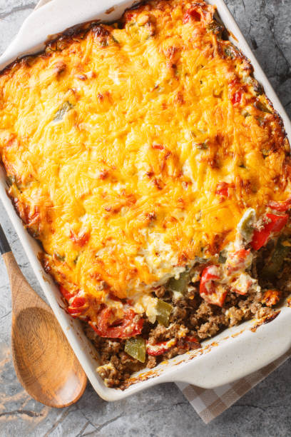 istock John Wayne Casserole is an easy ground beef casserole with a biscuit base and loaded with vegetables and a cheesy topping closeup on the baking dish. Vertical top view 2157318903