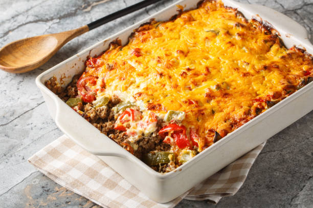 istock Classic John Wayne casserole has wonderfully southwest flavors, ground beef, a biscuit crust, fresh tomatoes, and a cheesy creamy topping closeup on the baking dish. Horizontal 2157318915