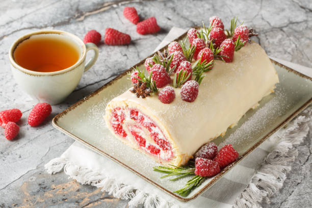 istock Christmas roll cake with cream, jam and fresh raspberries closeup on the plate. Horizontal 2157319034