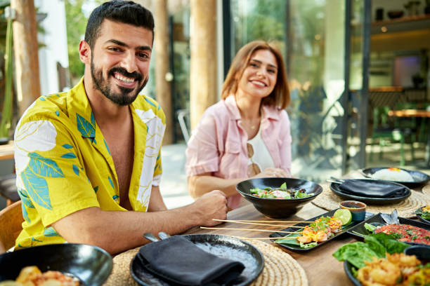 istock Smiling couple sitting at dining table in resort 2157320861