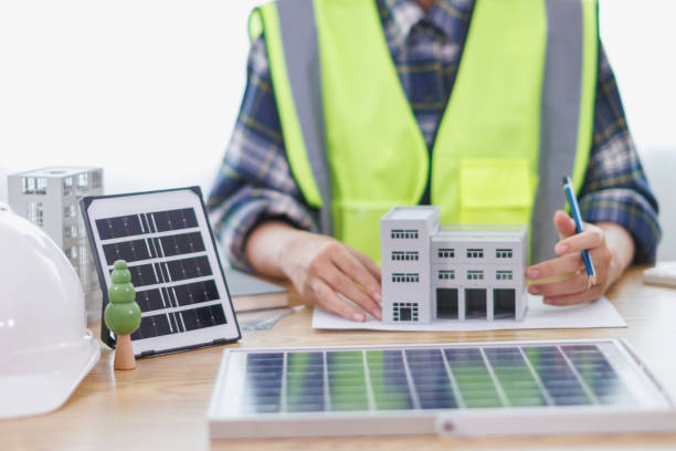 istock Engineers are reviewing plans from architects to prepare to install solar panels and wind turbines on the building to efficiently produce electricity using the concept of green energy from solar cells 2157323283