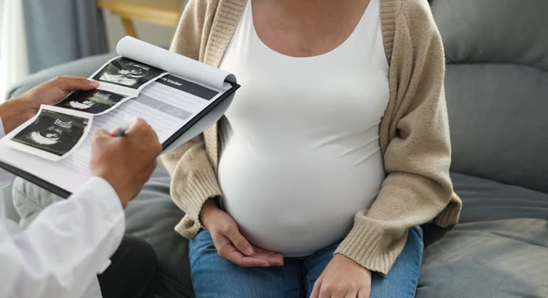 Pregnant asian woman visiting obstetrician, monitoring baby's health