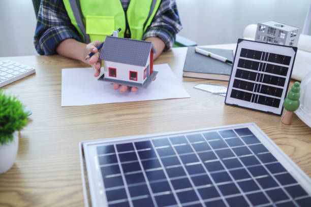 istock Engineers are reviewing plans from architects to prepare to install solar panels and wind turbines on the building to efficiently produce electricity using the concept of green energy from solar cells 2157324217