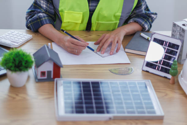 istock Engineers are reviewing plans from architects to prepare to install solar panels and wind turbines on the building to efficiently produce electricity using the concept of green energy from solar cells 2157324222