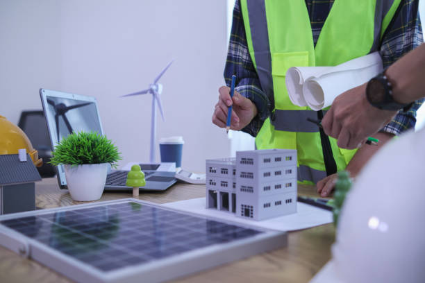 istock Engineers are reviewing plans from architects to prepare to install solar panels and wind turbines on the building to efficiently produce electricity using the concept of green energy from solar cells 2157324262