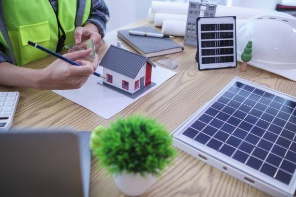 istock Engineers are reviewing plans from architects to prepare to install solar panels and wind turbines on the building to efficiently produce electricity using the concept of green energy from solar cells 2157324263