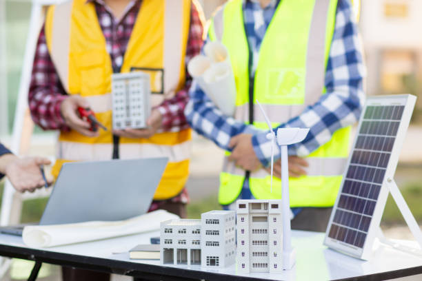 istock Engineers are reviewing plans from architects to prepare to install solar panels and wind turbines on the building to efficiently produce electricity using the concept of green energy from solar cells 2157324329