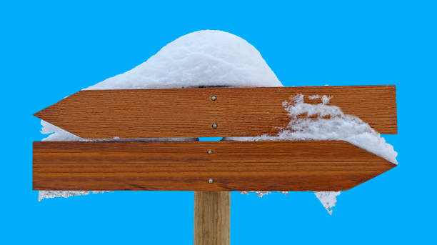 istock Wooden direction sign snow covered isolated on blue 2157324488