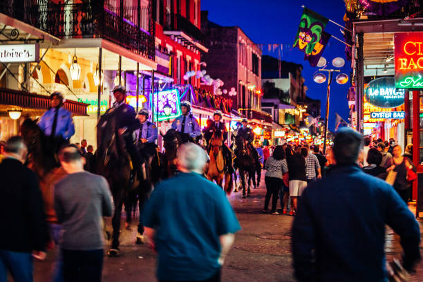 New Orleans, Louisiana, USA - Bourbon street is full of people during Mardi Gras parade. Mounted police going through the crowd.