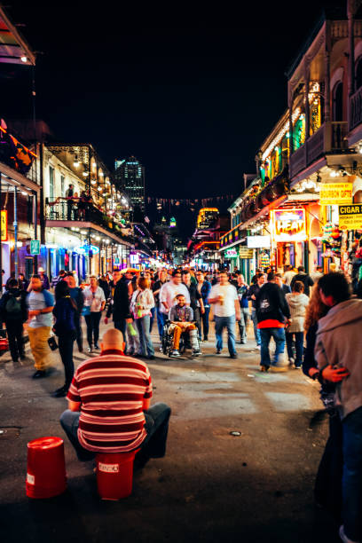 New Orleans, Louisiana, USA - Bourbon street is full of people during Mardi Gras parade. Street musicain performing.