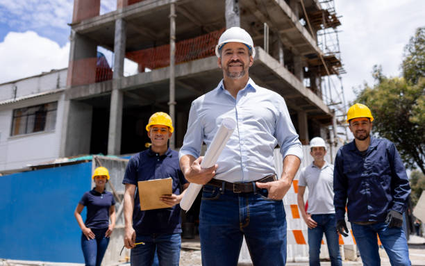 istock Architect leading a group of construction workers at a building site 2157325528