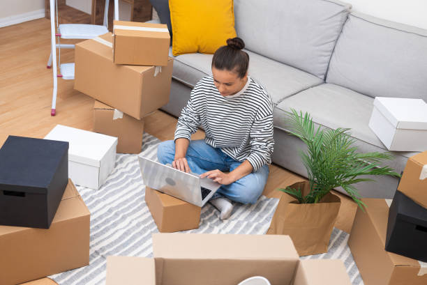 istock Woman amidst boxes, works on her laptop, exploring interior design, online shopping, 2157332572