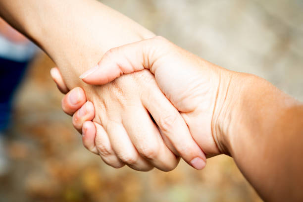 Two women shaking hands outdoors. Team work and agreement setting concept. Women solidarity and support. Caucasian palm. Strength and collaboration. fingers with blurred background. Make business. High quality photo