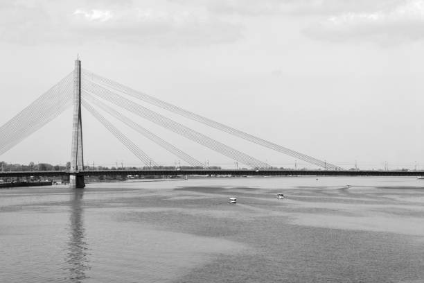 Black and white image of a bridge over a river in the morninging