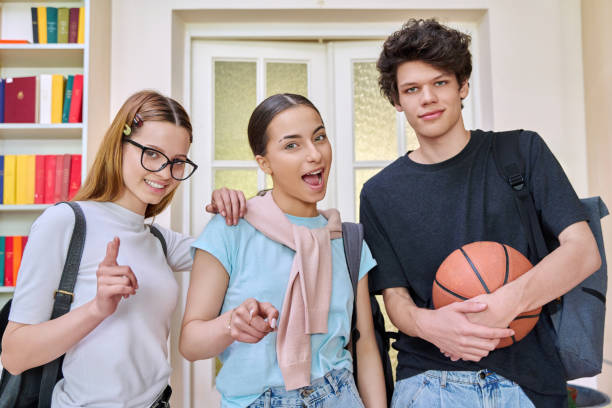 istock Three cheerful teenagers students looking at camera inside school campus 2157339047