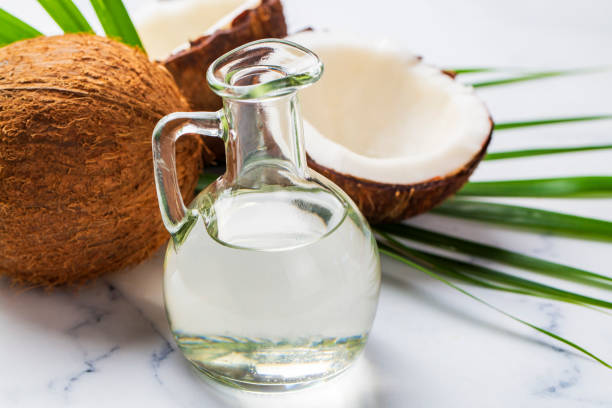 istock Bottle of coconut oil and fresh coconuts with palm leaf 2157340846
