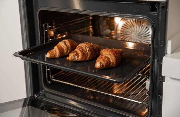 istock Croissants on a baking sheet in the built-in oven in the kitchen 2157345309