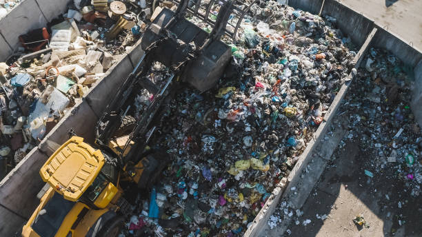 istock Skid loader scooping, lifting, and dumping garbage, top down aerial shot 2157345706