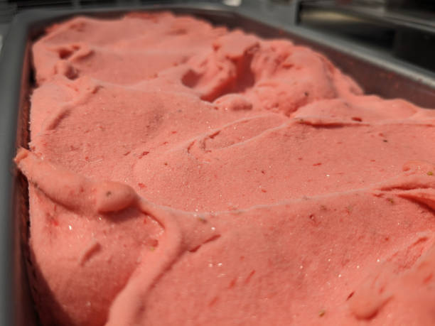 istock container with strawberry ice cream,  closeup on the store counter. 2157348046