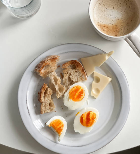 Hard boiled eggs, whole grain bread toast and cheese served with cup of coffee. Healthy breakfast meal. Top view