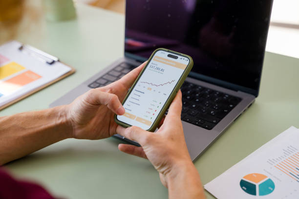 istock Financial analyst checking investments app on smartphone with laptop 2157349500
