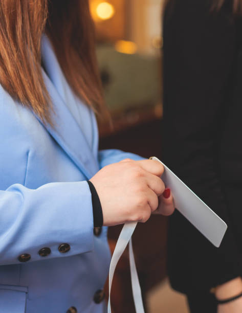 istock Process of checking in on a conference congress forum event, registration desk table, visitors and attendees receiving a name badge and entrance wristband bracelet and register electronic ticket 2157349890