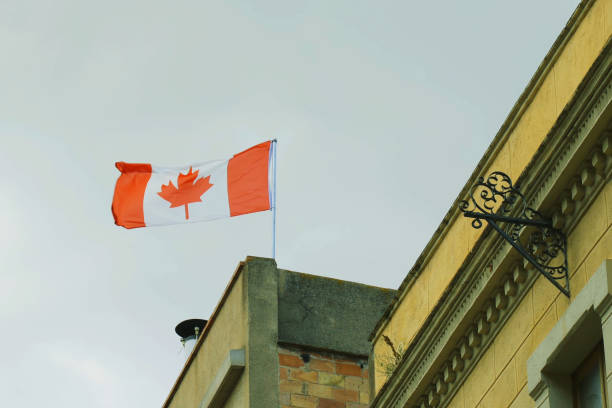 istock Canadian Flag Flying Atop Building 2157353366