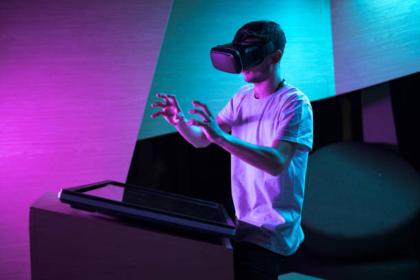 istock Young man in VR glasses standing making hand gestures in the air 2157353997