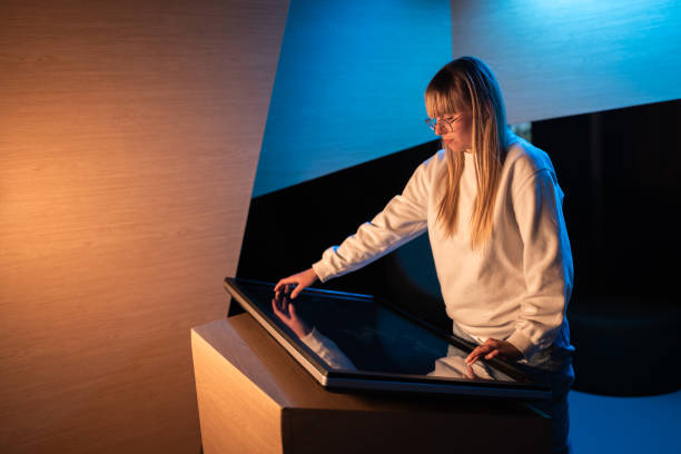 istock Adolescent girl using touch screen display on museum exhibition 2157354180
