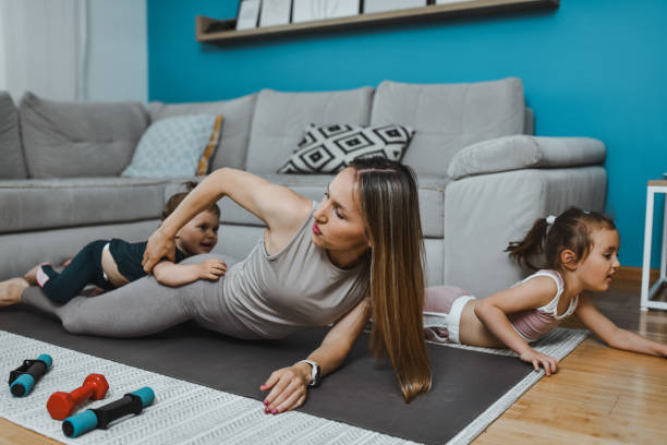 istock Mother Playing With Child Daughters On Yoga Mat 2157356851