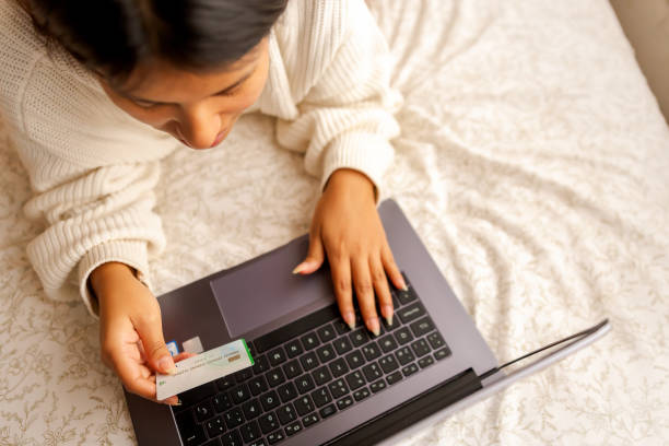 women Conducting Financial Transactions Online in the bed. Copyspace