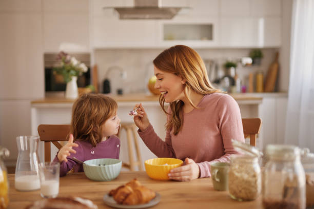 istock Mother having a breakfast with her little girl in the kitchen 2157363579