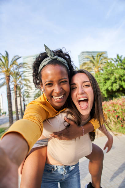 istock two women are taking a selfie together in a park 2157364254