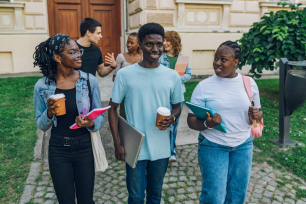 istock Happy diverse students walking at campus away from university after class 2157364655